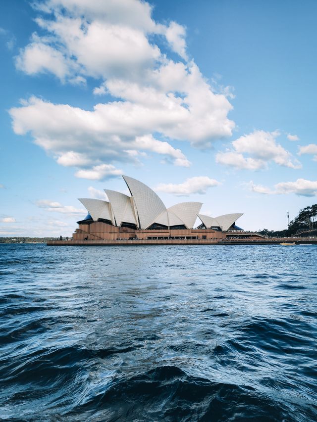 Sydney Opera House and Harbour Bridge seen across the water at golden hour