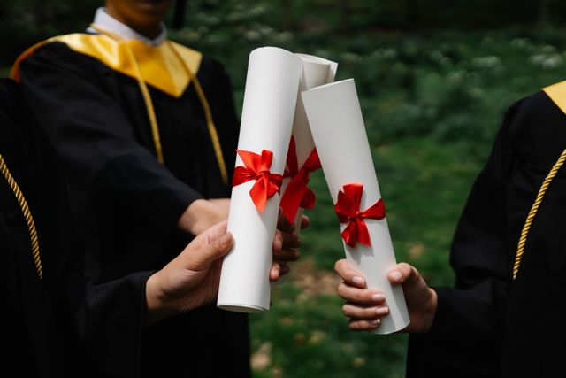 International student in a graduation gown holding a degree certificate and smiling